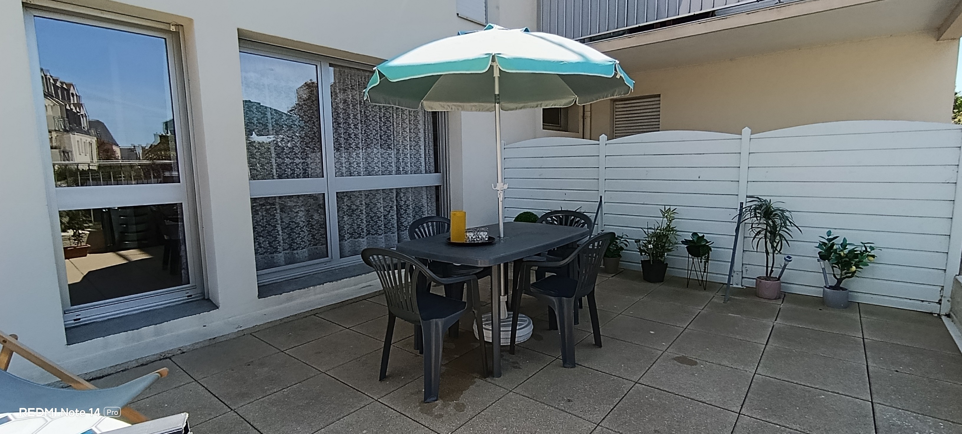 A lovely 25 m² terrace with garden furniture, 1 sun lounger and 1 parasol.  The terrace overlooks lush green surroundings.