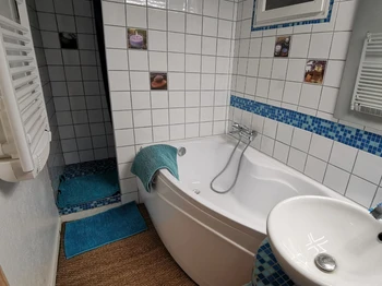 Salle d'eau avec baignoire et douche