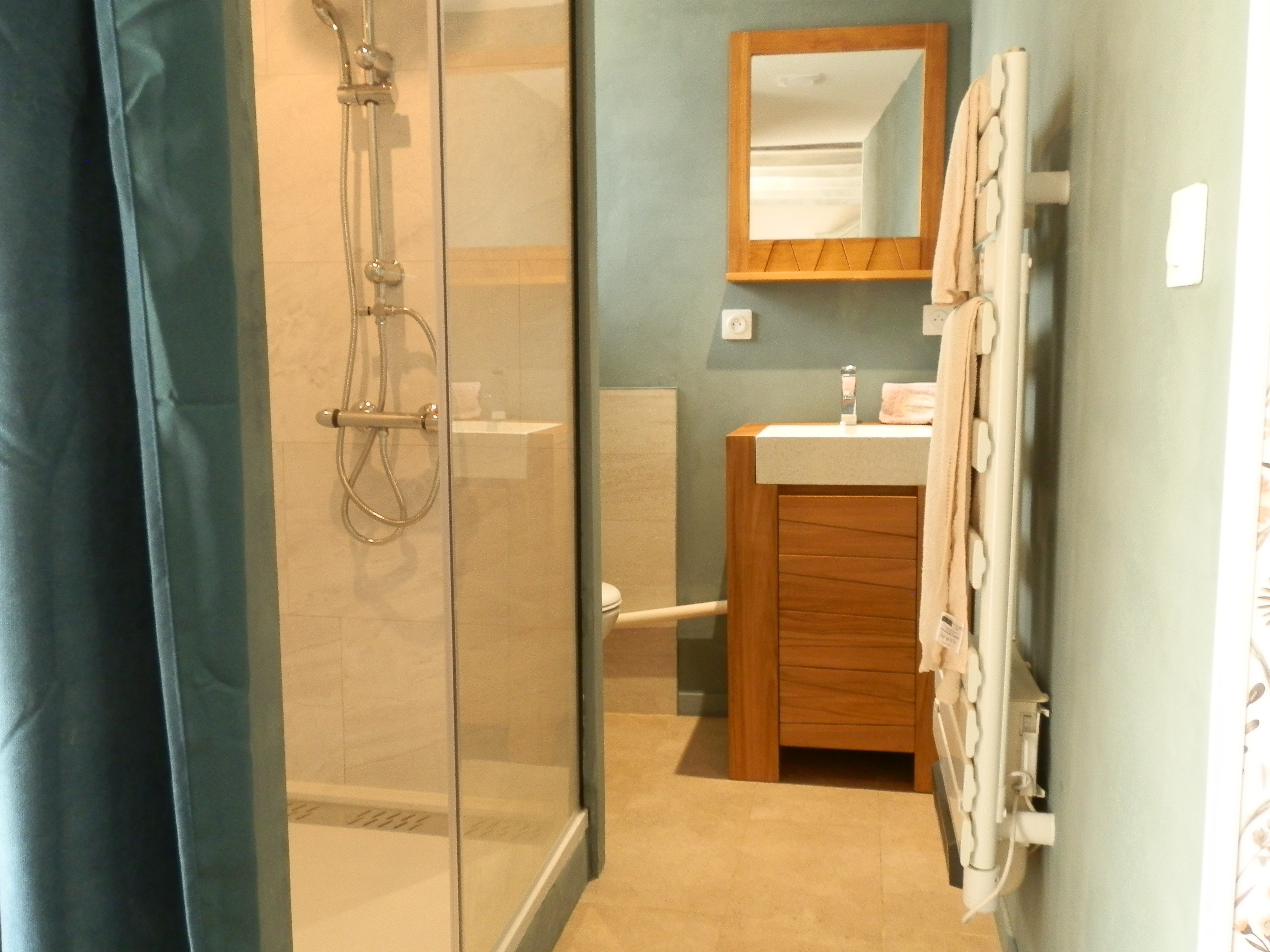 Salle d'eau avec douche grande dimension, meuble vasque et WC.