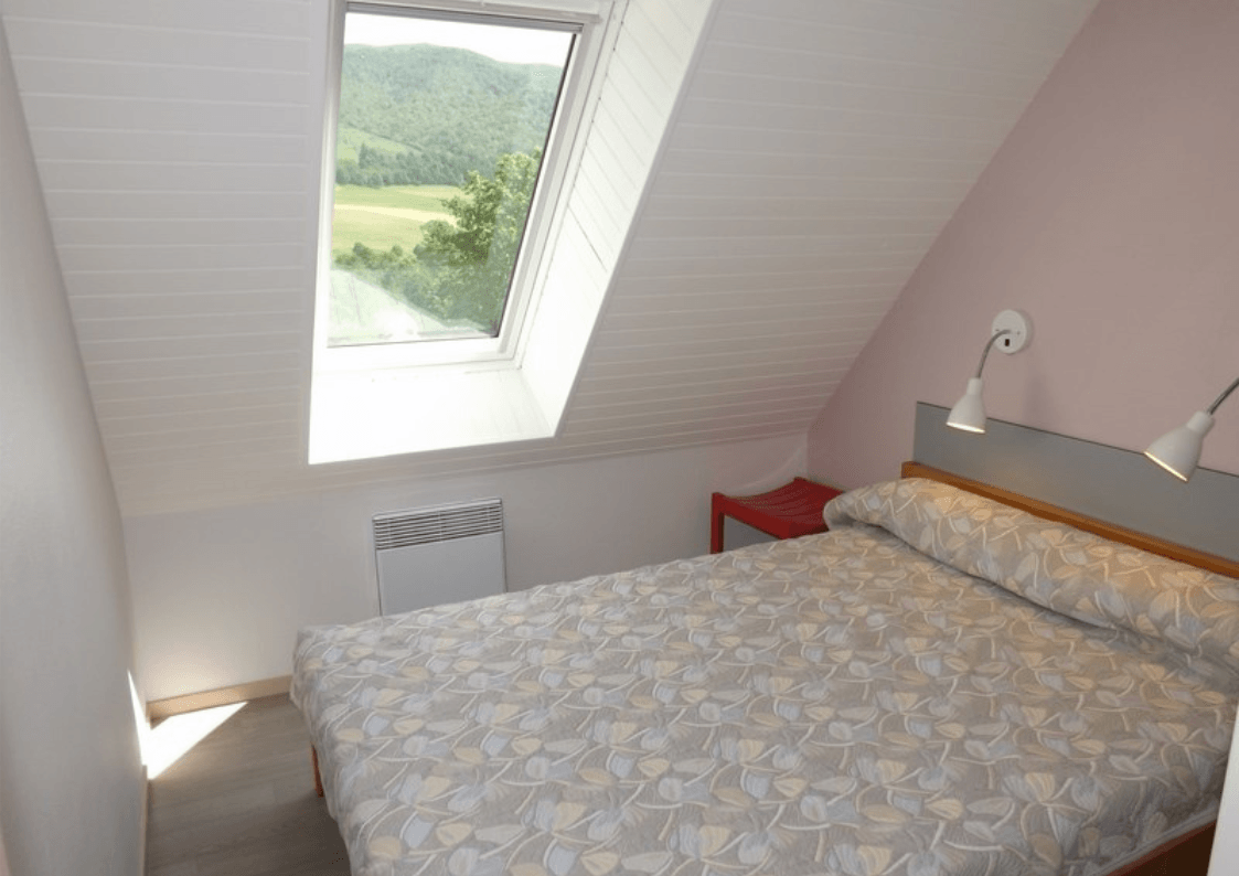 Chambre avec lit double, décoration fonctionnelle et vue dégagée.