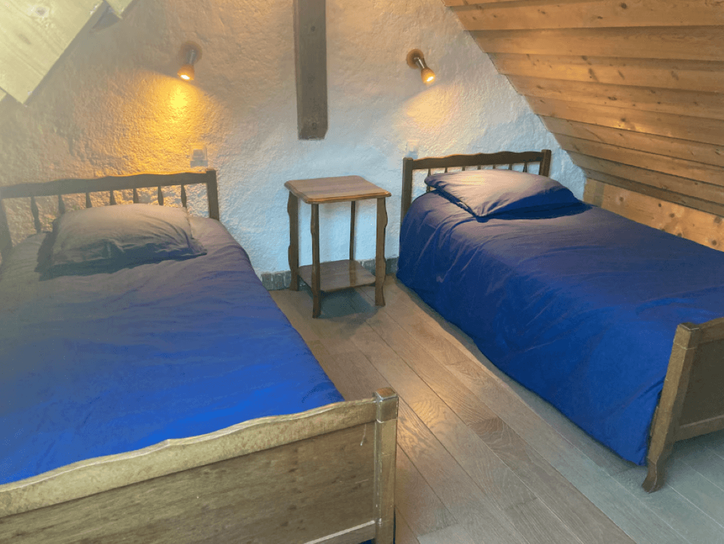 Upstairs, there is a bedroom with two single beds