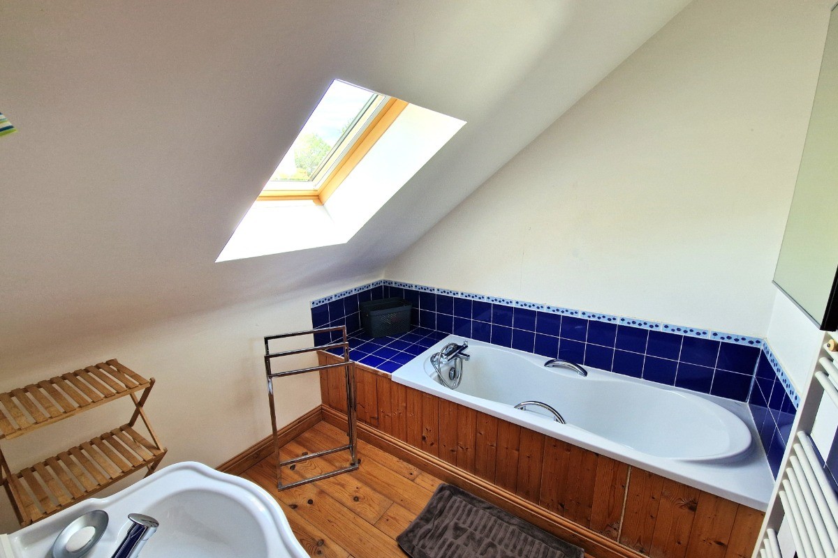 La salle de bain au 2nd étage, avec baignoire grande dimension. Parquet au sol.