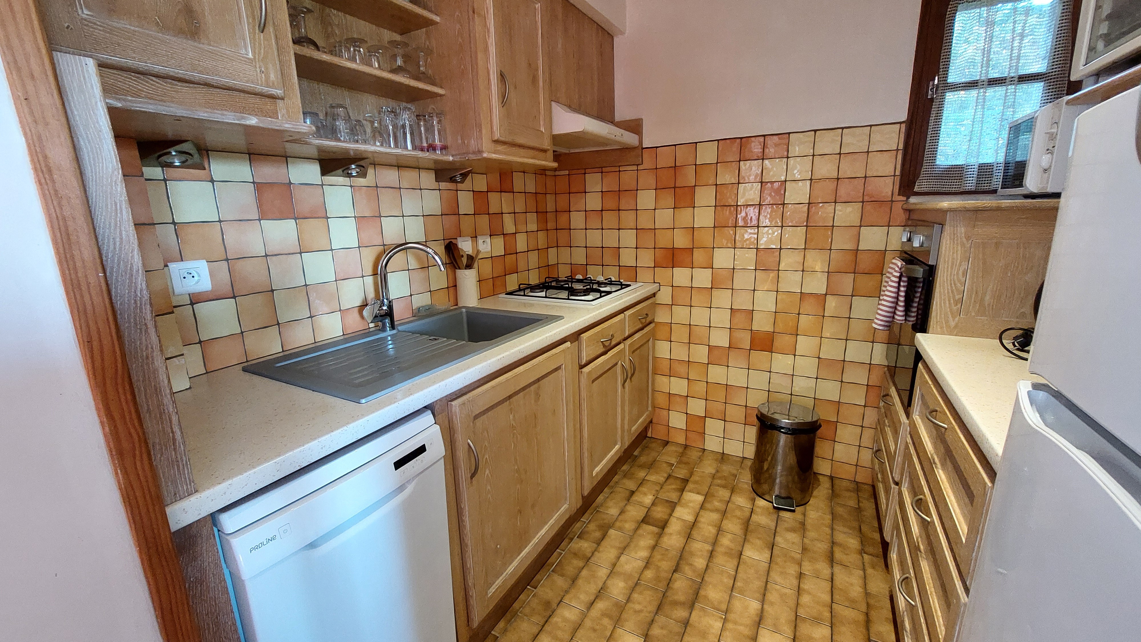 Cuisine équipée du gîte avec plan de travail et vue sur le séjour.