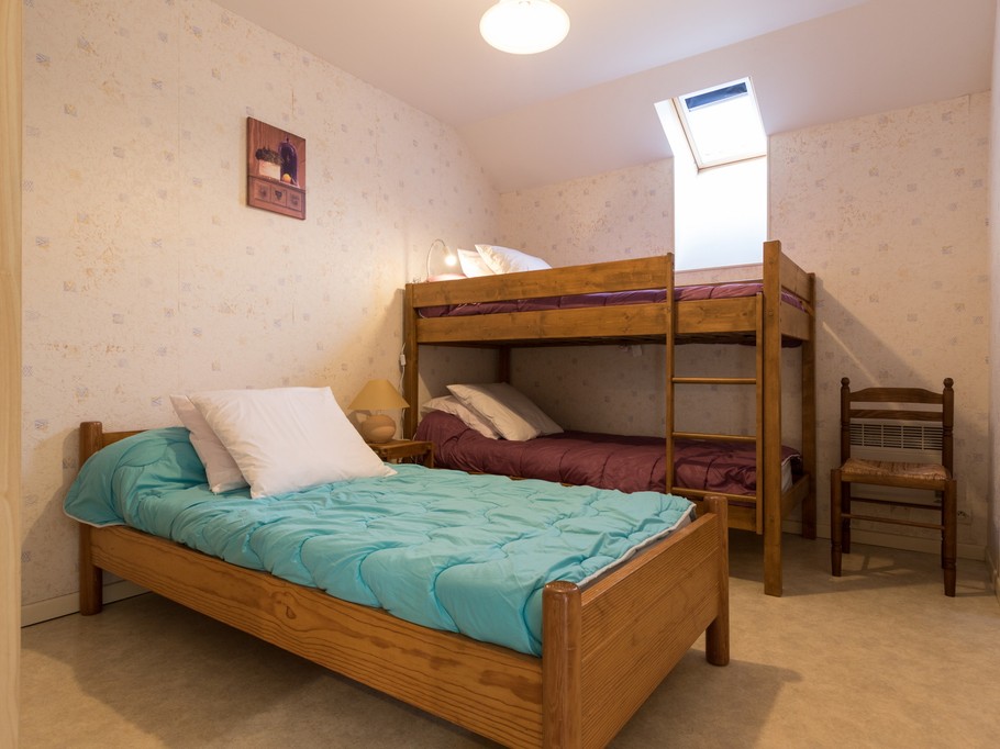 Chambre 2, trois lits en 90 cm dont deux superposés. Vélux occultant et grande penderie-lingère sur la gauche.