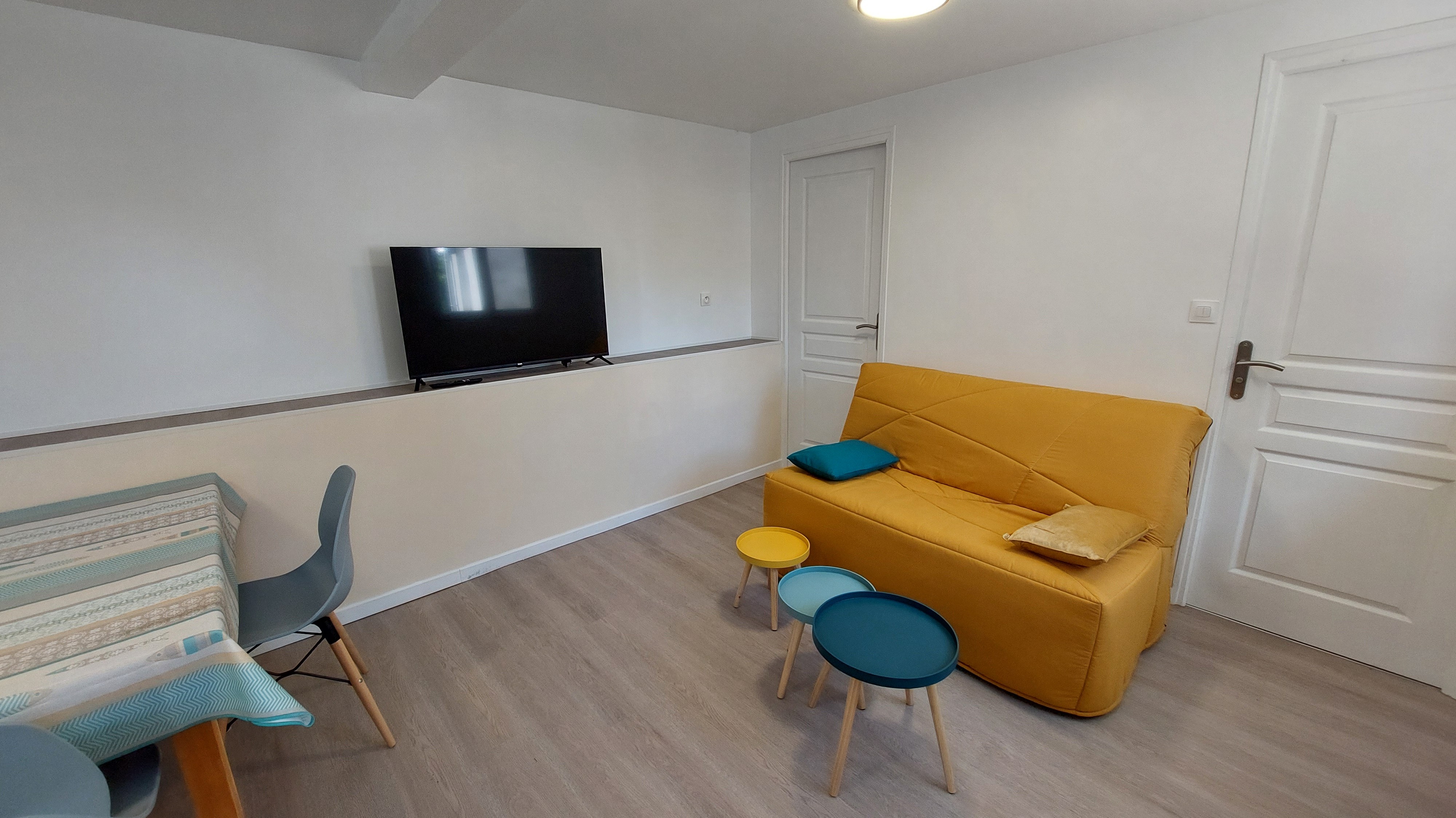 Salon avec canapé et télévision dans un gîte rénové
