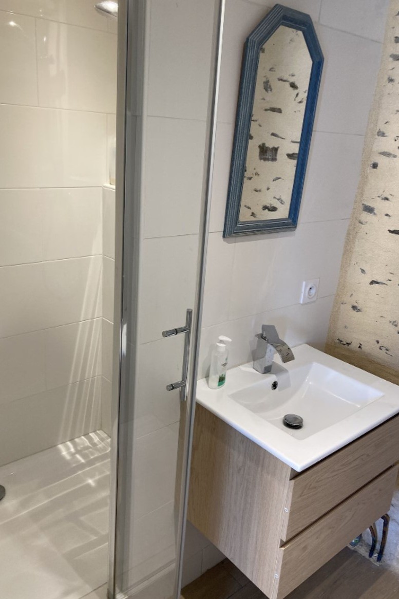 Salle d'eau avec douche grande dimension et meuble vasque Chambre dans la bâtisse annexe de l'autre côté de la terrasse.