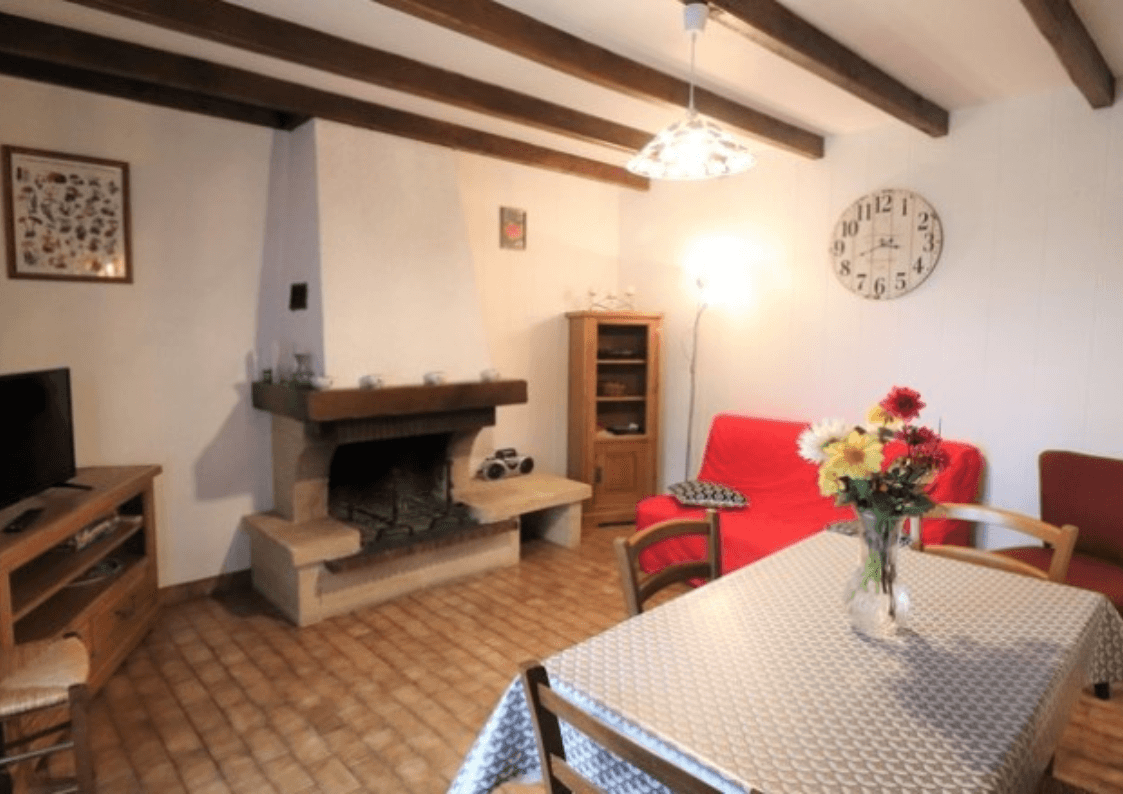 Séjour rustique avec cheminée, espace cosy et ouverture sur la campagne.