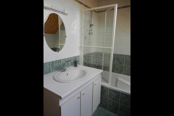 Salle de bain avec baignoire, radiateur sèche serviette et wc