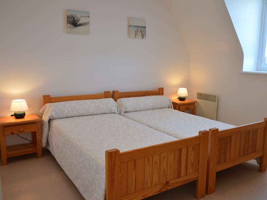 Chambre indépendante pour 2 personnes avec 2 lits 90x190 cm, commode, armoire et chaise.