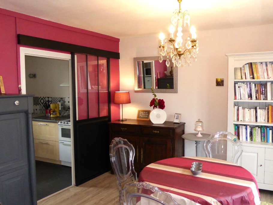 Living area with library. Separate kitchen to the left.
