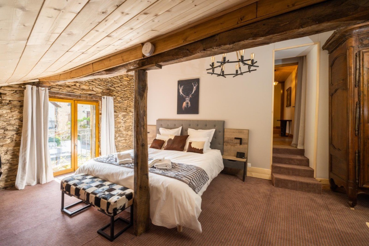 Chambre spacieuse avec lit en 180 cm et décoration élégante au gîte de Leynhac. Accès au jacuzzi