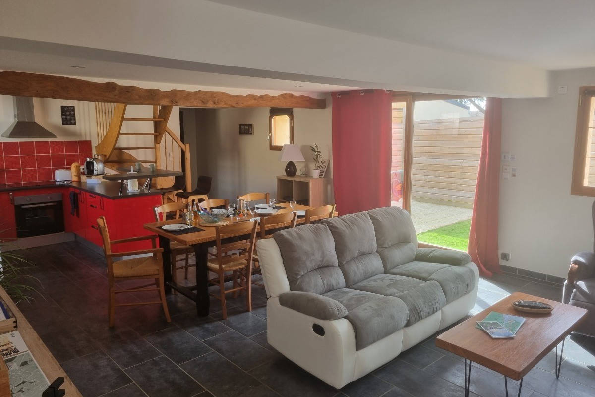 Séjour spacieux, salon, cuisine ouverte, baie vitrée donnant accès à la cour