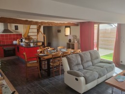 Séjour spacieux, salon, cuisine ouverte, baie vitrée donnant accès à la cour