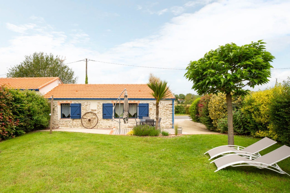 Jardin privatif avec terrasse, salon de jardin, parasol, transats, fils à linge et barbecue.