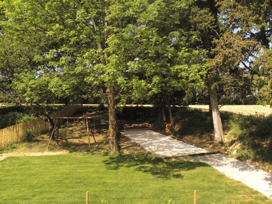 Terrain de pétanque et balançoire à l'ombre