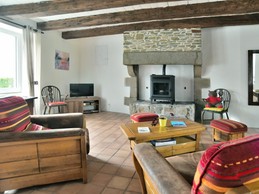 Coin salon dans la pièce de vie de 62m² avec poêle (pelé).