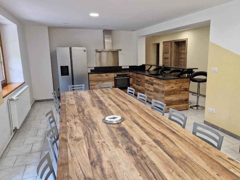Cuisine équipée avec sa belle tablée et son bar américain au rez-de-chaussée - Gîte de la Haute Hardoye (14 pers) dans les Vosges
