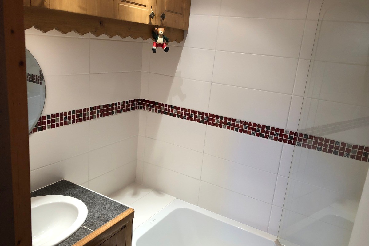 La salle de bain avec grande baignoire et douche intégrée