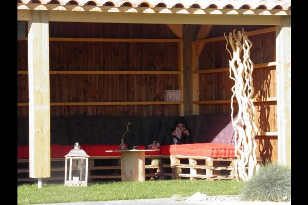 A côté de la piscine, préau avec livres à disposition en saison