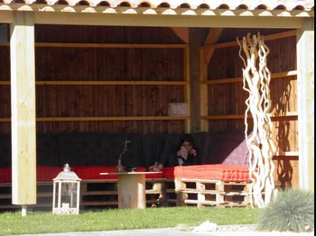 A côté de la piscine, préau avec livres à disposition en saison