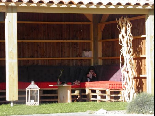 A côté de la piscine, préau avec livres à disposition en saison