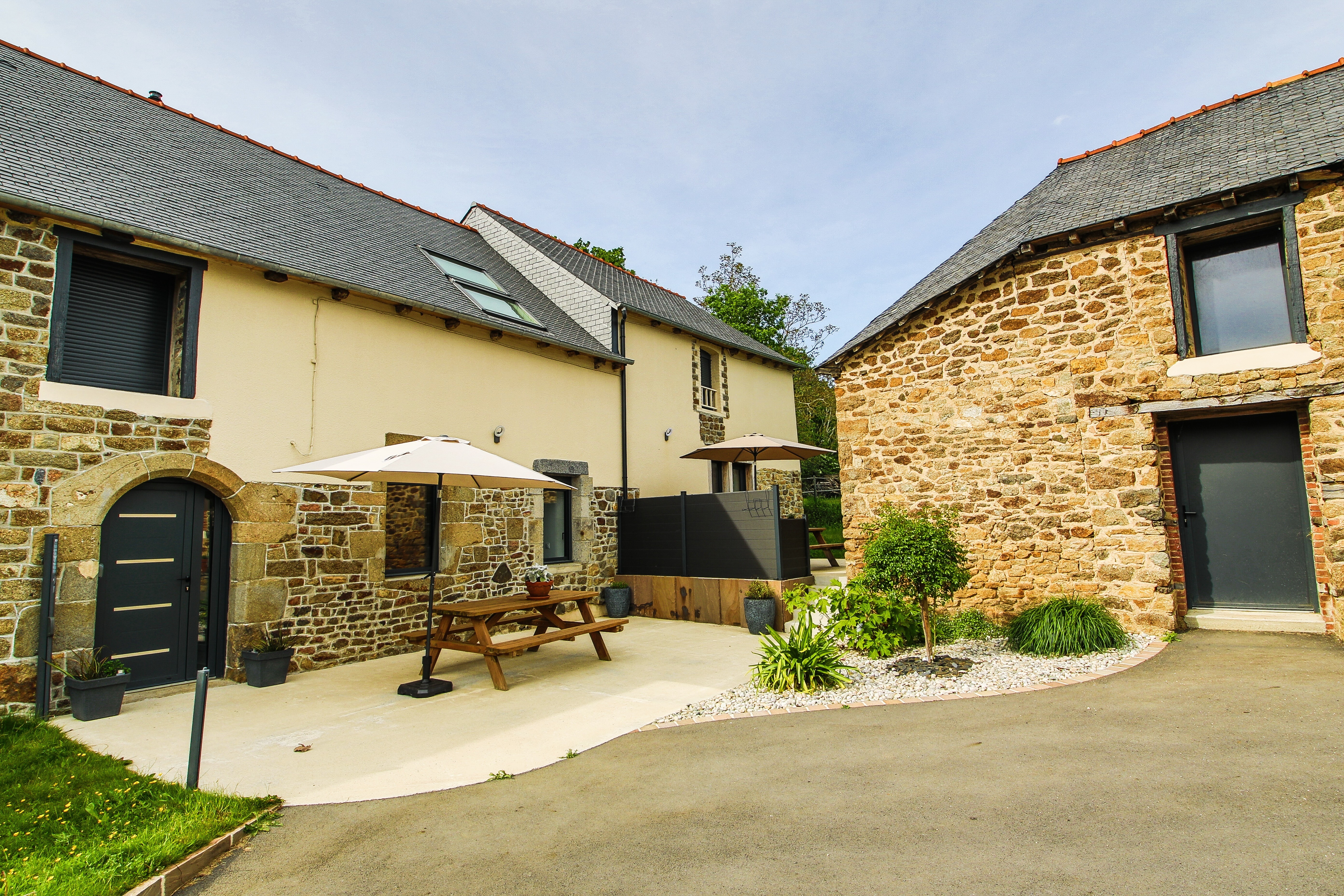 Façade du gîte avec sa terrasse. Autre gîte mitoyen à droite