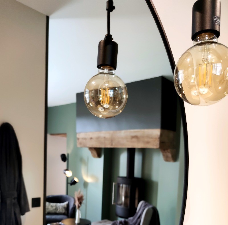 Détail de l'appartement de plain pied : coin salon avec poêle à bois