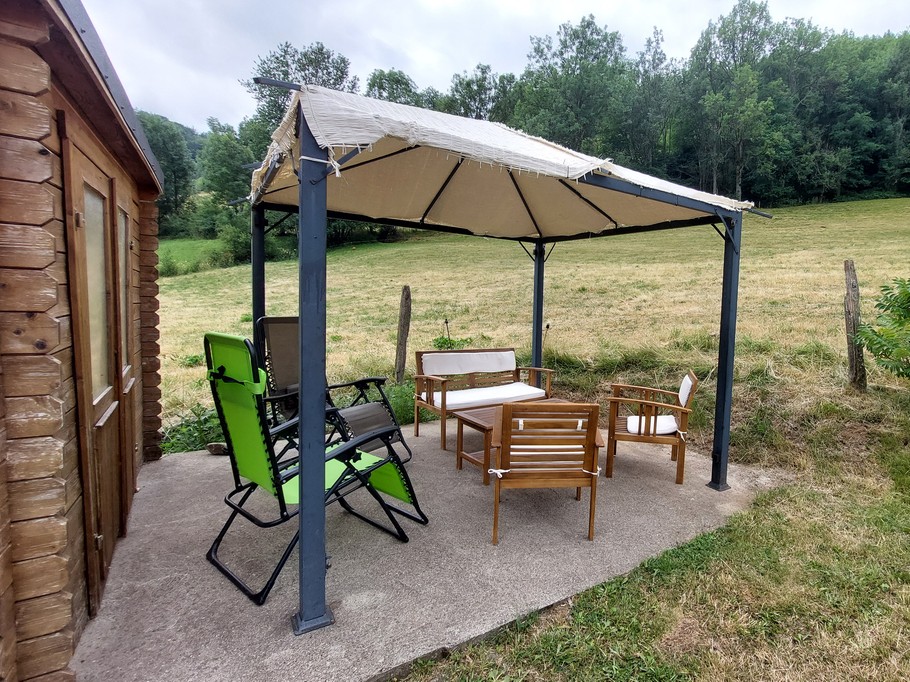 Salon de jardin sous tonnelle avec vue sur la montagne – Gîte à Laveissière dans le Cantal