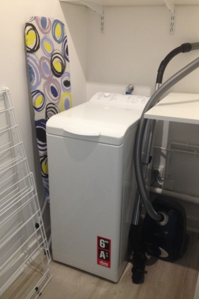 buanderie avec lave linge, étandage à linge, fer et table à repasser, aspirateur