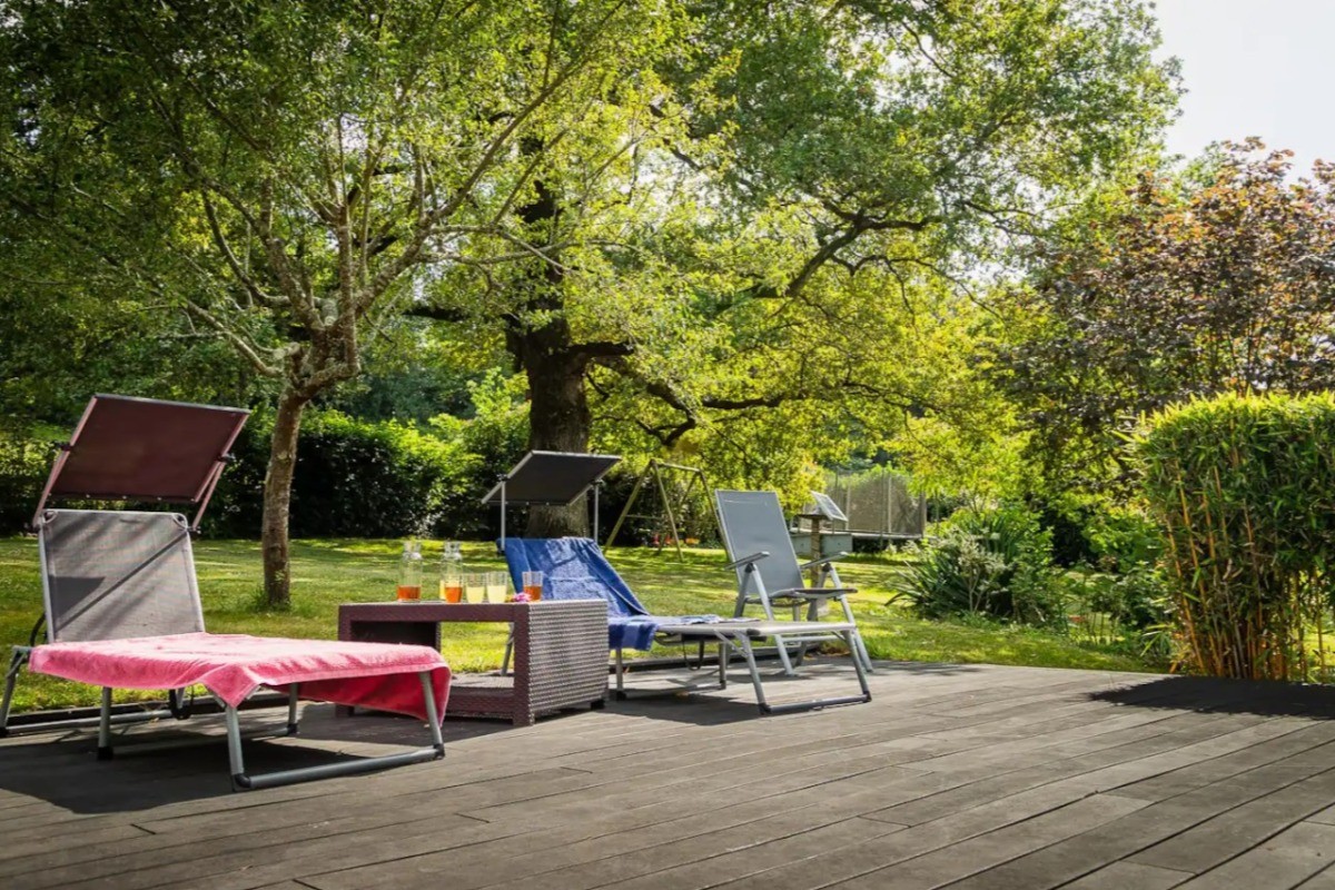 Bains de soleil sur la terrasse en bois qui bordent la piscine commune autres voyageurs.