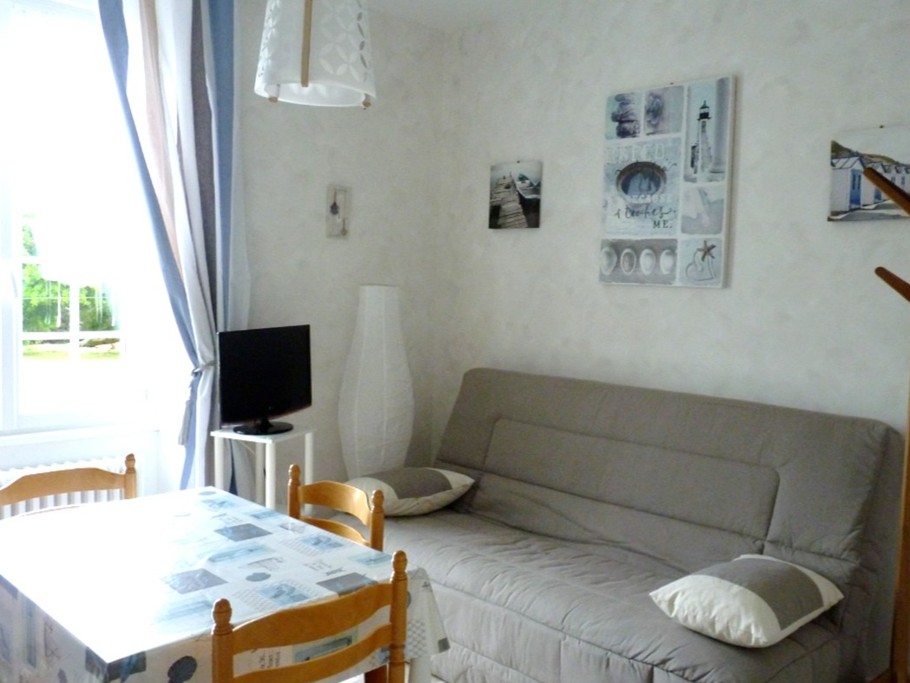 Pièce de vie en RDC avec coin cuisine bien équipée et coin salon avec TV.