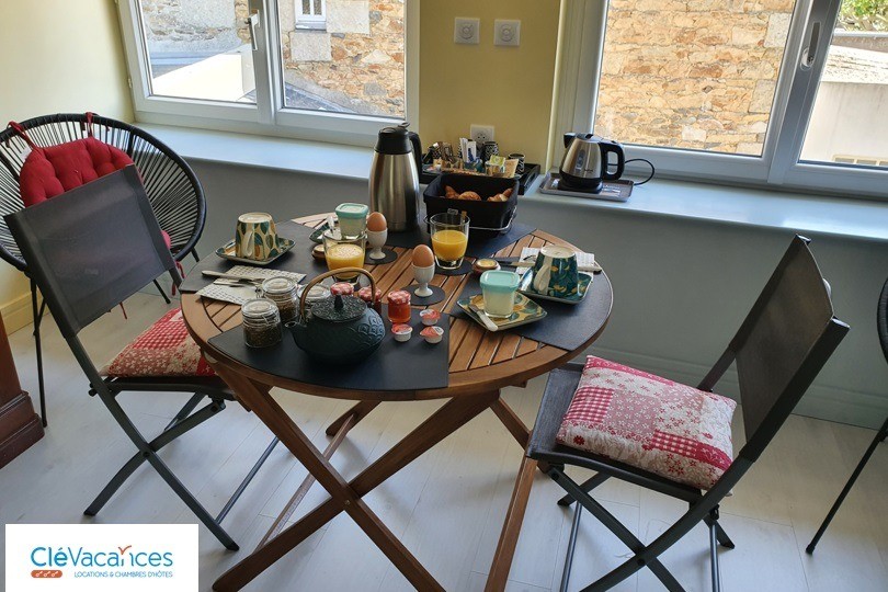 Clévacances, la chambre avec son espace table et salon, côté cour et place de l'église