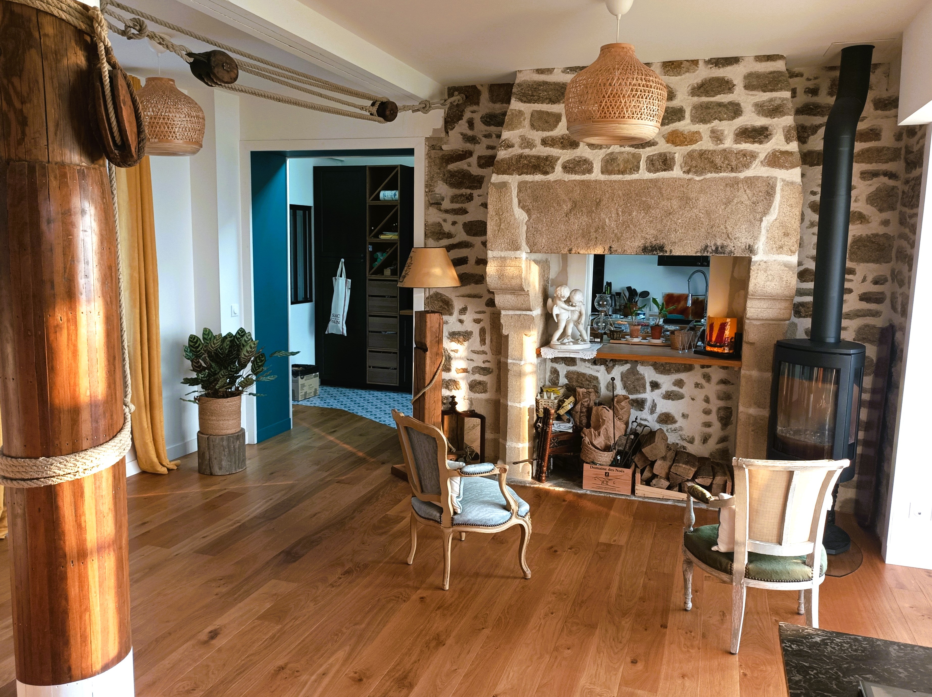 Grande pièce de vie avec 2 salons, un poêle à bois, un séjour dans la véranda vue mer.