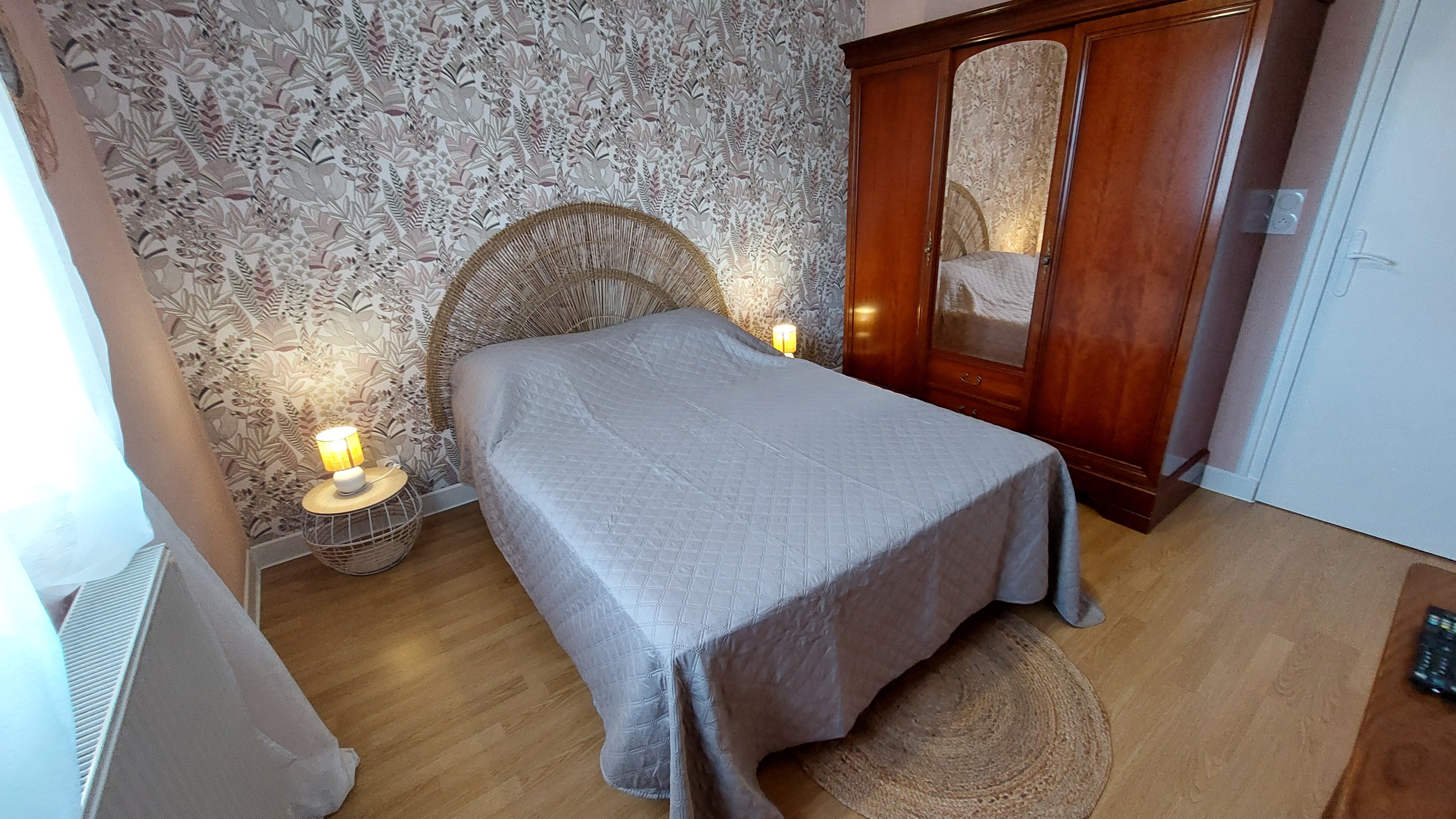 Chambre cosy avec lit double et tête de lit en rotin