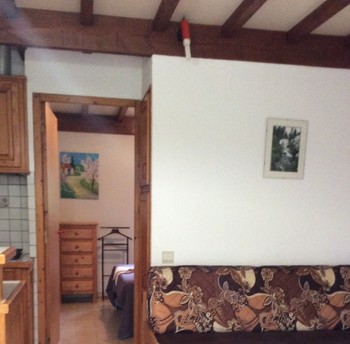 Le séjour avec le canapé et la chambre au fond