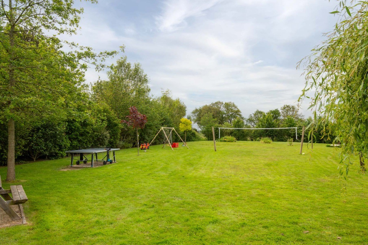 Parc de loisirs avec jeu sur ressort, balançoire, table de ping pong, terrain de volley, terrain de pétanque. Ballons, frisbees, boules de pétanque, raquettes et balles à disposition.