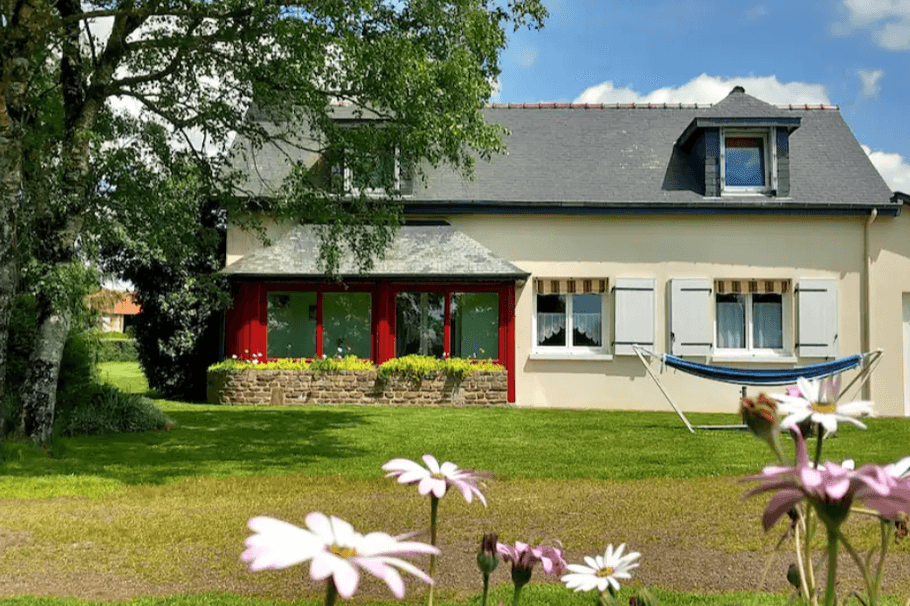 Façade de la maison, avec véranda et garage à droite.