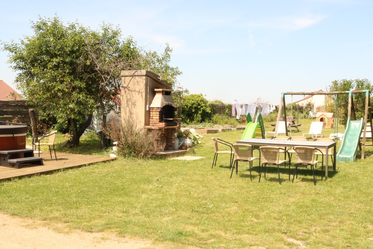 The garden with its barbecue, spa, garden furniture, slide and swing