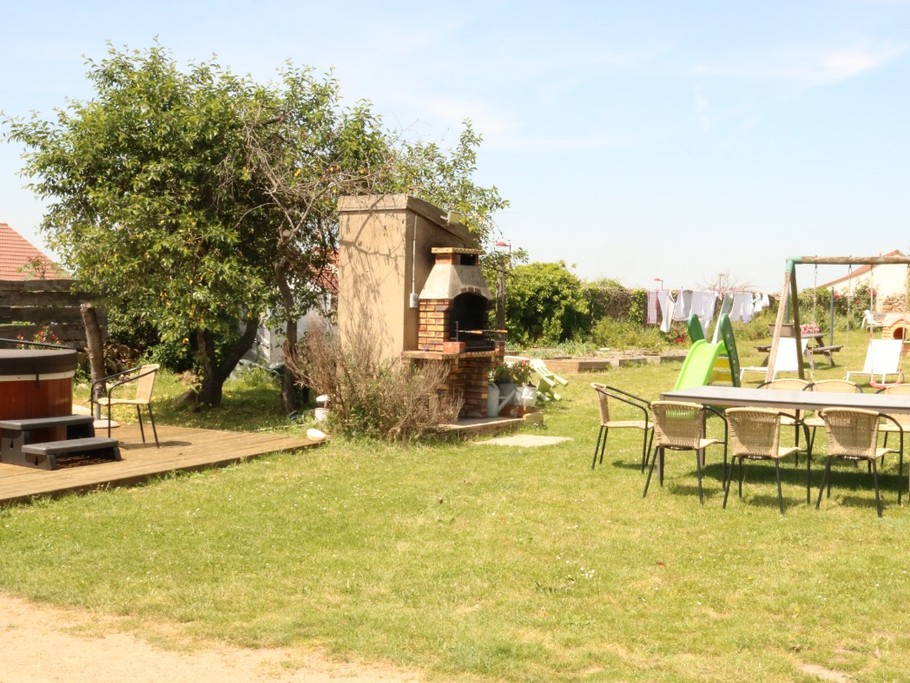 The garden with its barbecue, spa, garden furniture, slide and swing