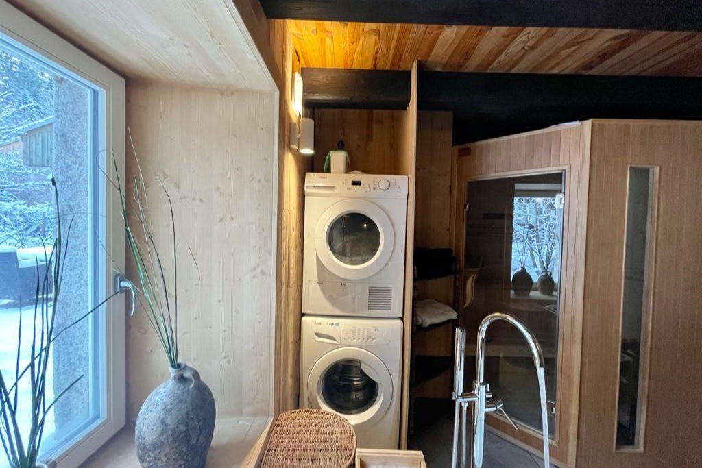 Sauna traditionnel dans salle de bains et équipements : lave-linge, sèche-linge