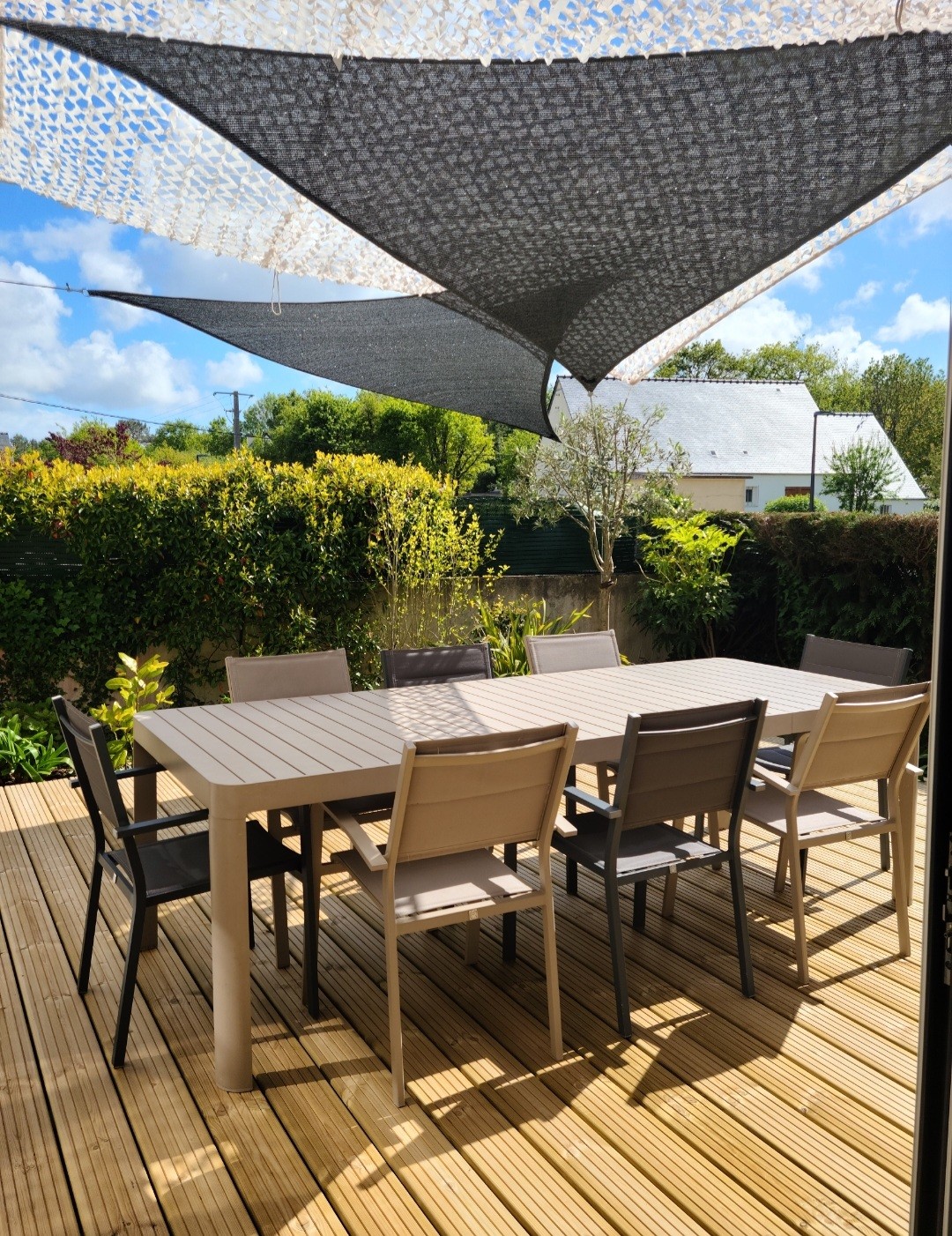 Table d'extérieur sous voiles d'ombrage.