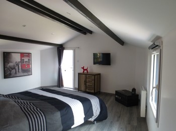 Chambre rouge avec lit Queen size (160), placard et TV.