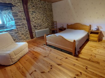 Vue lumineuse de la chambre avec lit d'appoint idéale pour séjour familial ou professionnel dans le Cantal