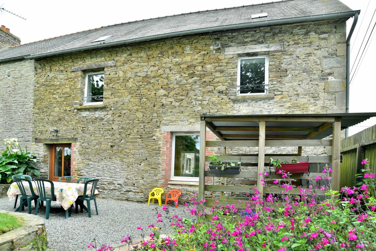 L'arrière de la maison avec terrasse, jardin et abris.