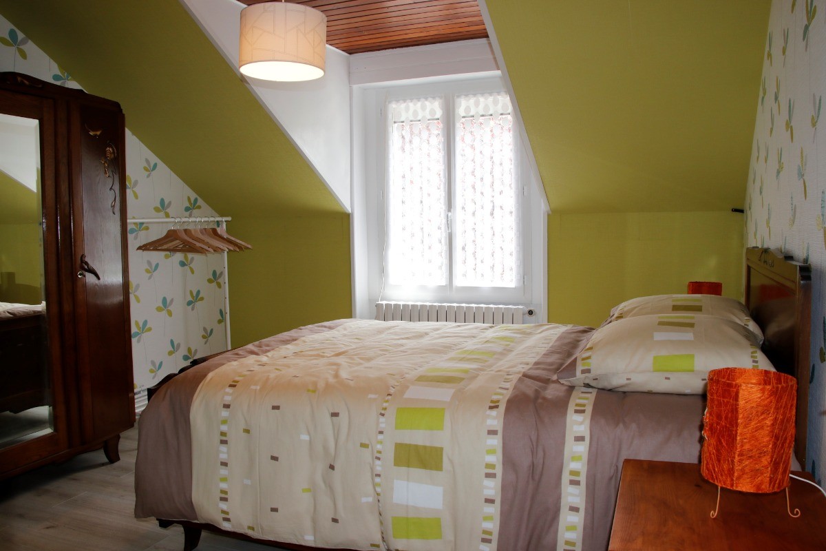 Chambre confortable avec lit double et décoration rustique, parfaite pour une nuit paisible