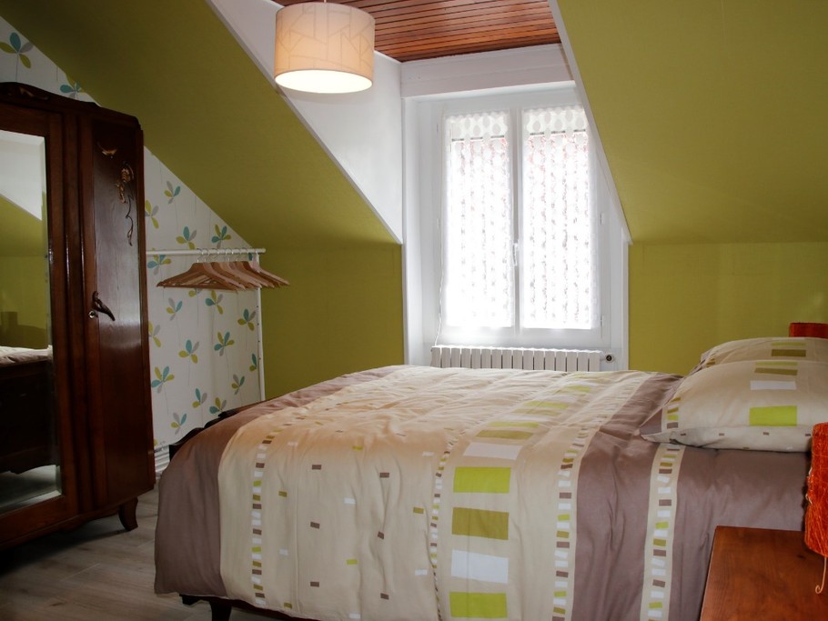 Chambre confortable avec lit double et décoration rustique, parfaite pour une nuit paisible