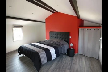 Chambre rouge avec lit Queen size (160), placard et TV.