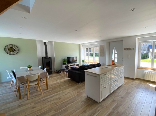 Grande pièce de vie lumineuse avec coin cuisine, coin salon et coin séjour. Accès à la terrasse par la baie vitrée côté séjour.