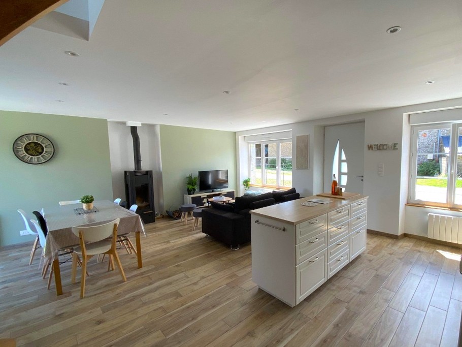 Grande pièce de vie lumineuse avec coin cuisine, coin salon et coin séjour. Accès à la terrasse par la baie vitrée côté séjour.