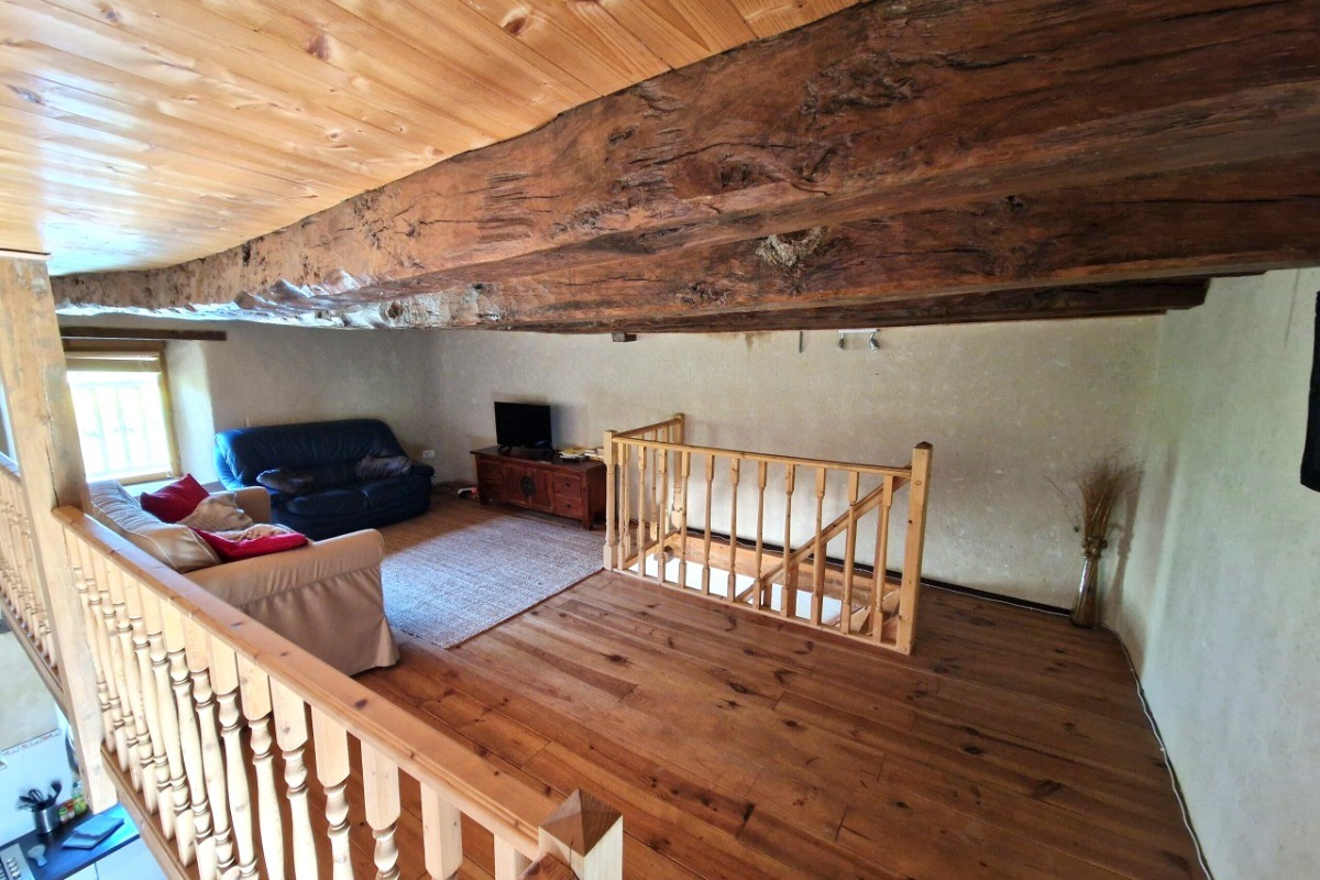 Mezzanine au 1er étage avec coin détente et TV.